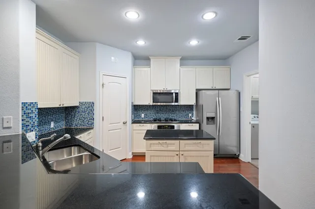 a kitchen with stainless steel appliances a refrigerator and a stove top oven
