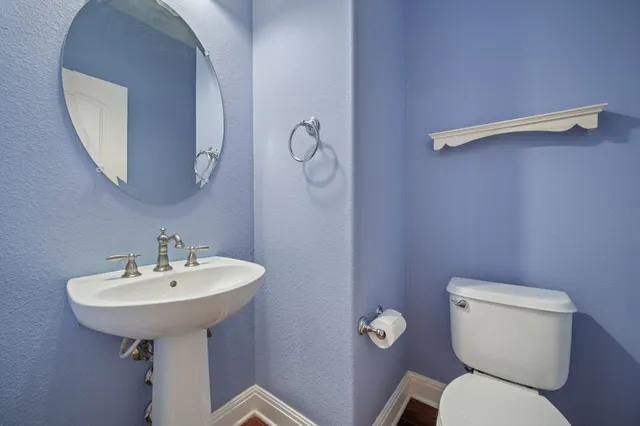 a bathroom with a toilet a sink and a mirror