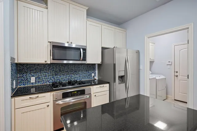 a kitchen with stainless steel appliances white cabinets and a refrigerator oven