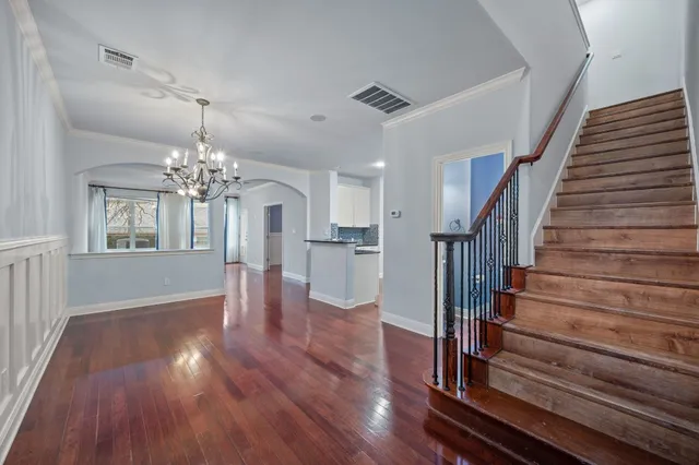 a view of a room with wooden floor staircase and a kitchen