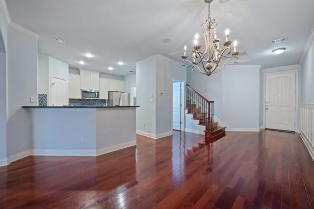 a view of a kitchen with wooden floor and stainless steel appliances