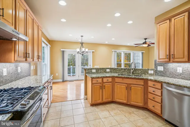 a large kitchen with stainless steel appliances granite countertop a stove and a sink