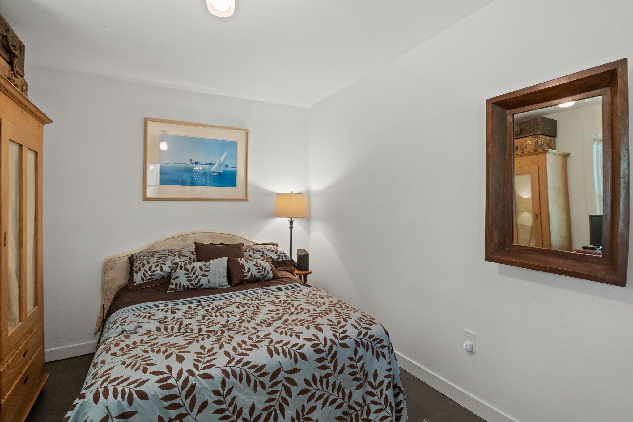 4 Pond Road, Unit B Truro, MA 02666 - Photo 25 of 40 a bedroom with a bed and a painting on the wall