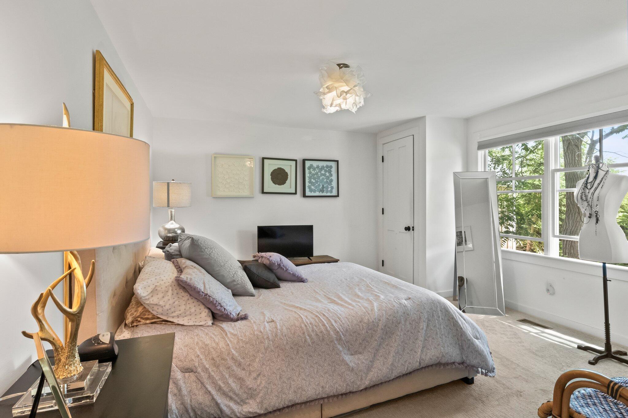 4 Pond Road, Unit B Truro, MA 02666 - Photo 27 of 40 a bedroom with a bed and a chandelier