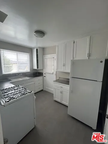a kitchen with stainless steel appliances a refrigerator sink and cabinets