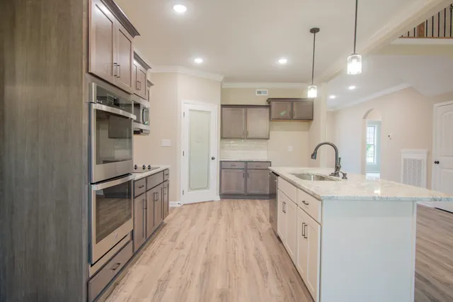 a kitchen with stainless steel appliances a sink stove and refrigerator