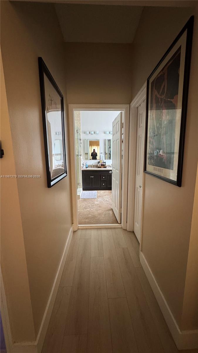 4220 Southwest 153rd Avenue Miramar, FL 33027 - Photo 17 of 34 a view of a hallway with wooden floor and a bathroom