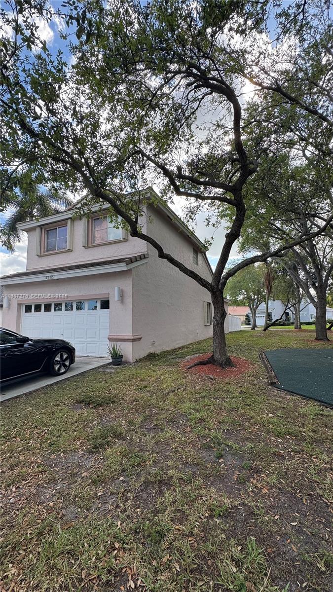 4220 Southwest 153rd Avenue Miramar, FL 33027 - Photo 2 of 34 a white house that has a tree in front of it