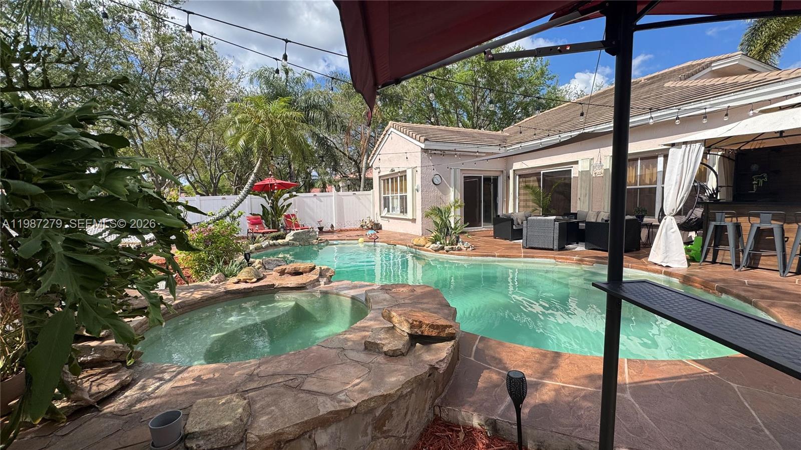 4220 Southwest 153rd Avenue Miramar, FL 33027 - Photo 31 of 34 a backyard of a house with yard table and chairs