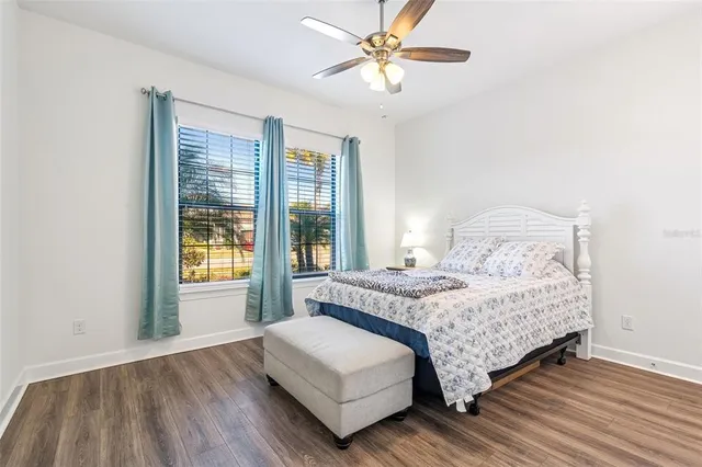 a bedroom with a bed a dresser and a large window