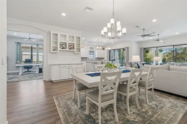 a large kitchen with granite countertop a large center island a sink stainless steel appliances and cabinets