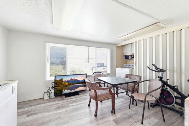 5480 South 2000th Street West Roy, UT 84067 - Photo 15 of 36 Versatile space featuring wood-finish flooring, a large window, built-in cabinetry, and a utility area with a washing machine
