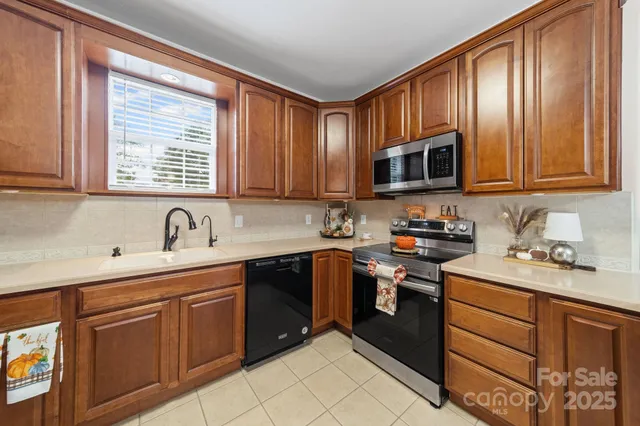 a kitchen with stainless steel appliances granite countertop a sink stove microwave and cabinets