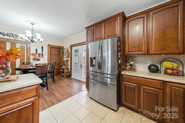 a kitchen with granite countertop a refrigerator a sink dishwasher and cabinets with wooden floor