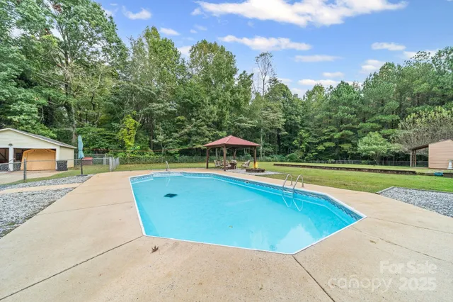 a view of a swimming pool and trees in the background