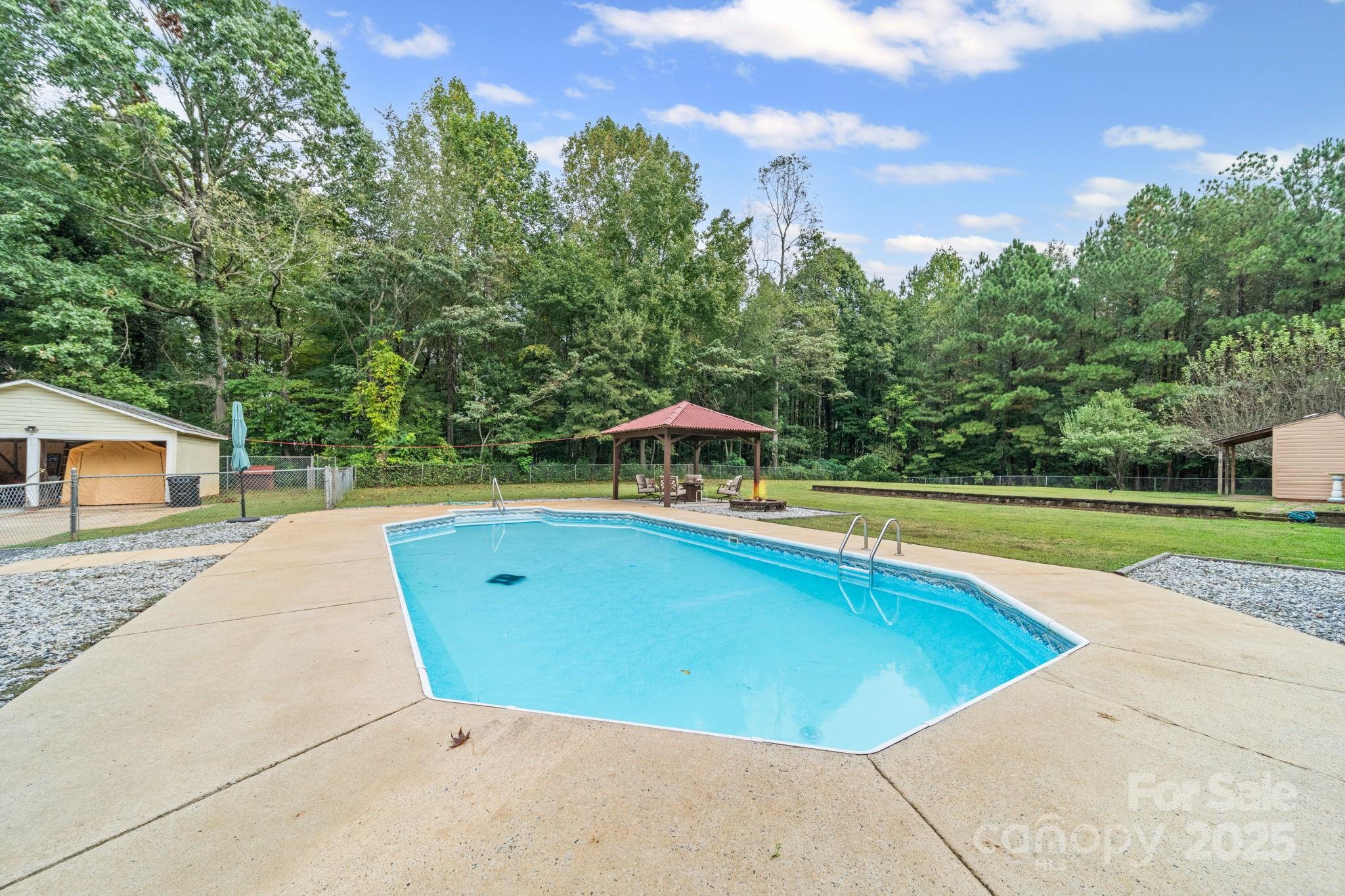 745 Dukeville Road Salisbury, NC 28146 - Photo 5 of 40 a view of a swimming pool and trees in the background