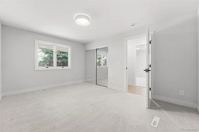 an empty room with windows and closet