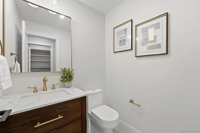 a bathroom with a granite countertop toilet and a sink