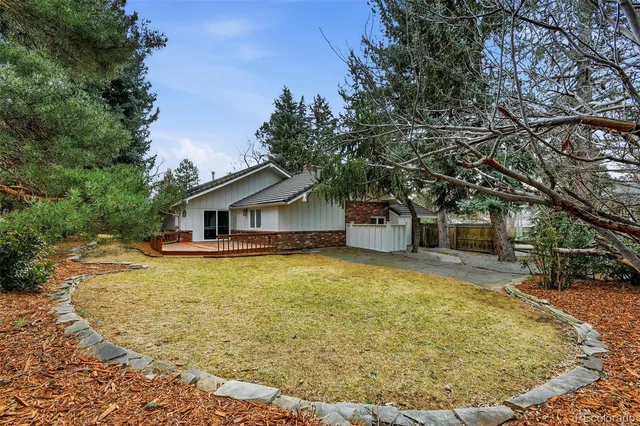 a swimming pool view with plants and large trees