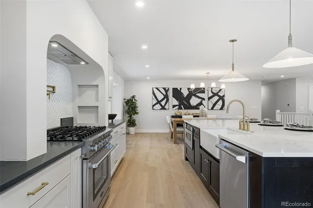a kitchen with stainless steel appliances a sink stove and cabinets