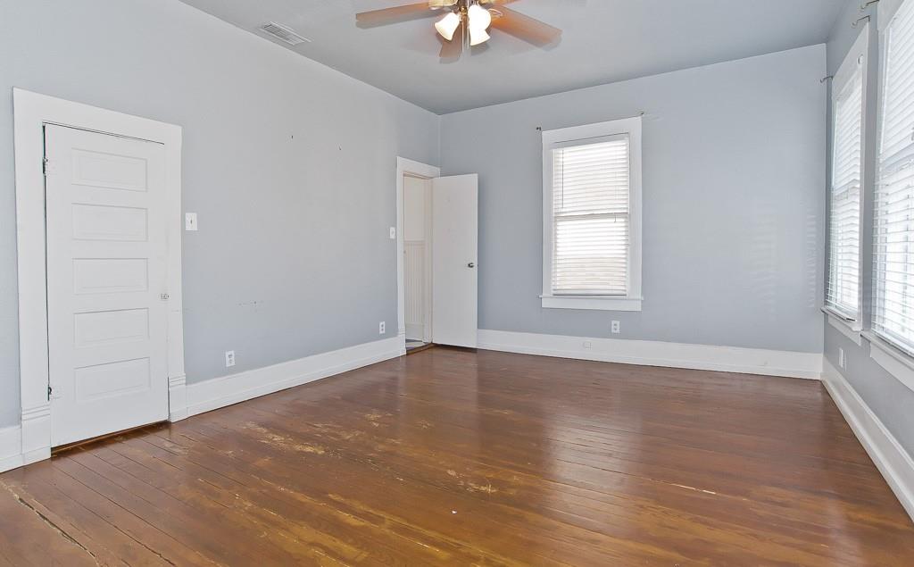 4910 Victor Street, Unit 4 Dallas, TX 75214 - Photo 13 of 24 an empty room with wooden floor chandelier fan and windows