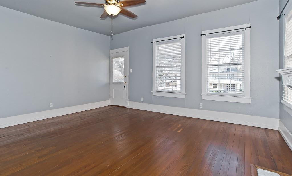 4910 Victor Street, Unit 4 Dallas, TX 75214 - Photo 4 of 24 an empty room with wooden floor chandelier fan and windows