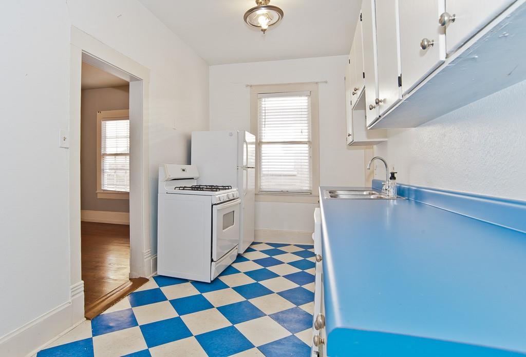 4910 Victor Street, Unit 4 Dallas, TX 75214 - Photo 9 of 24 a kitchen with a checkered floor and white cabinets