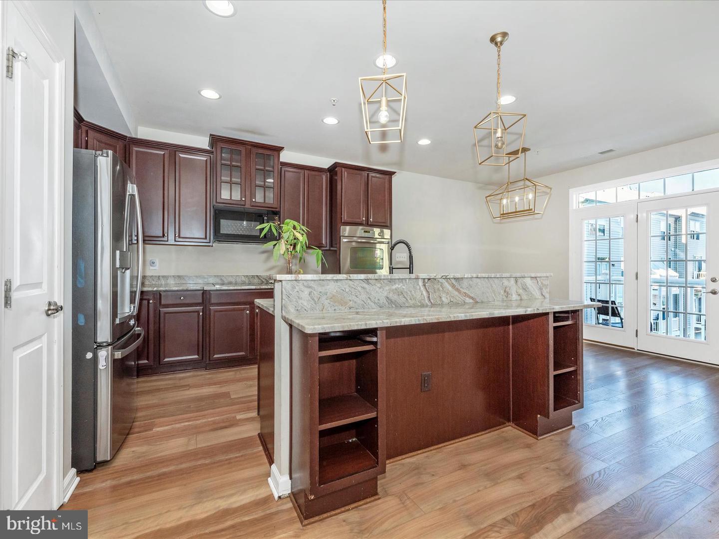 208 B Mill Pond Road Frederick, MD 21701 - Photo 8 of 45 a kitchen with kitchen island granite countertop wooden cabinets and a refrigerator