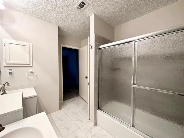 a bathroom with a shower and a sink
