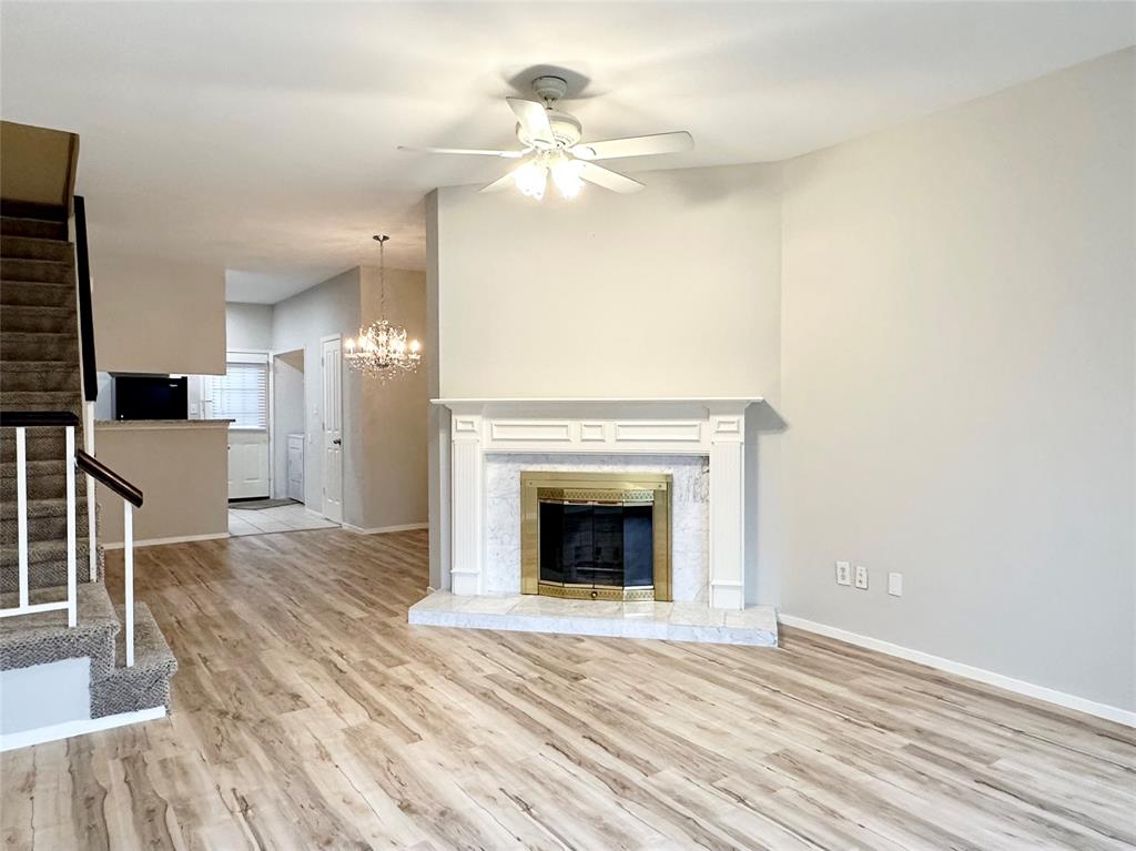 3801 14th Street, Unit 2305 Plano, TX 75074 - Photo 2 of 16 a view of a livingroom with a fireplace a ceiling fan and wooden floor