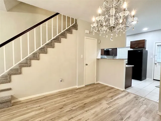 a view of a livingroom with wooden floor and a kitchen
