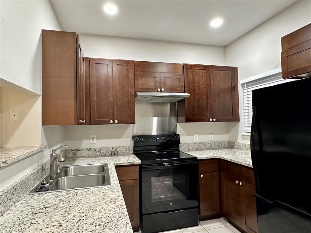 3801 14th Street, Unit 2305 Plano, TX 75074 - Photo 7 of 16 a kitchen with a refrigerator and a sink