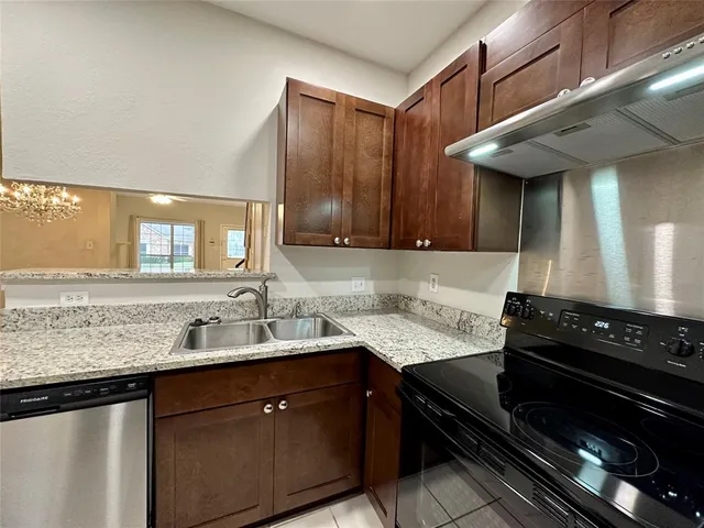 a kitchen with a sink a stove and cabinets