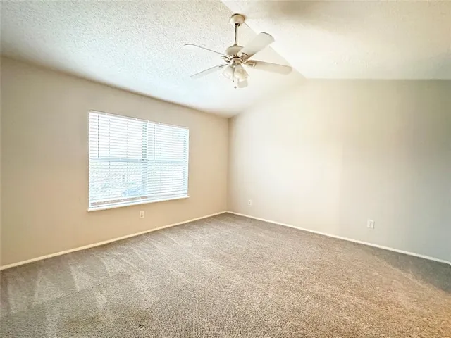 an empty room with a window and a fan