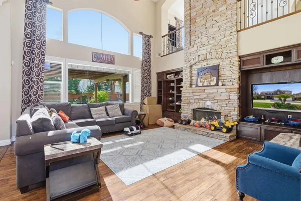 a kitchen with stainless steel appliances granite countertop a stove a refrigerator a kitchen island a refrigerator a dining table and chairs with wooden floor