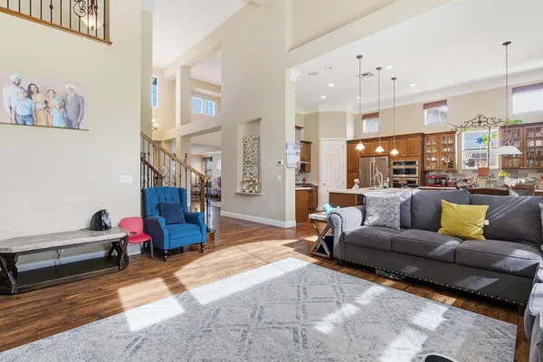 a kitchen with stainless steel appliances granite countertop a stove a sink dishwasher and a refrigerator with wooden floor