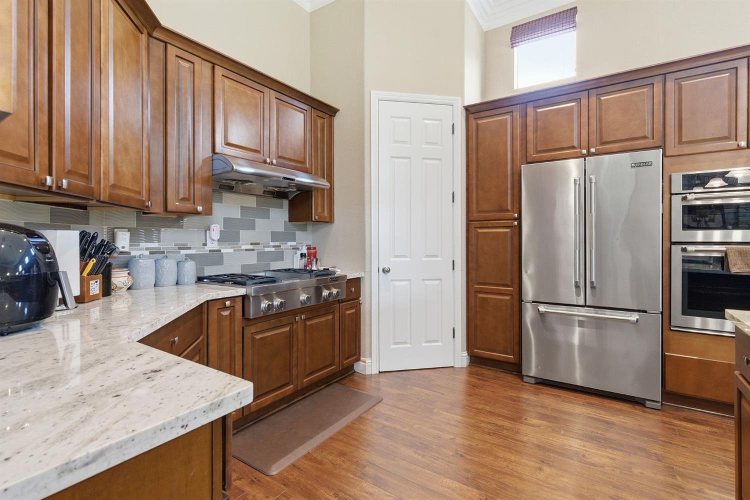 848 West Santos Avenue Ripon, CA 95366 - Photo 18 of 63 a kitchen with granite countertop wooden cabinets and stainless steel appliances