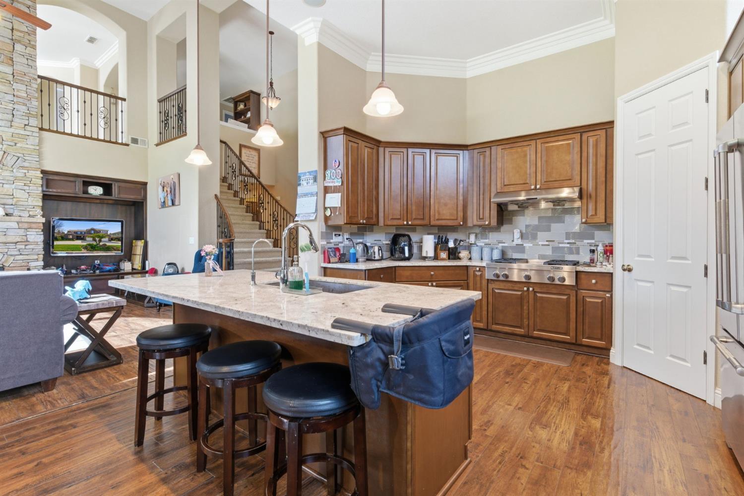 848 West Santos Avenue Ripon, CA 95366 - Photo 22 of 63 a kitchen with stainless steel appliances granite countertop a stove a sink dishwasher and a refrigerator with wooden floor