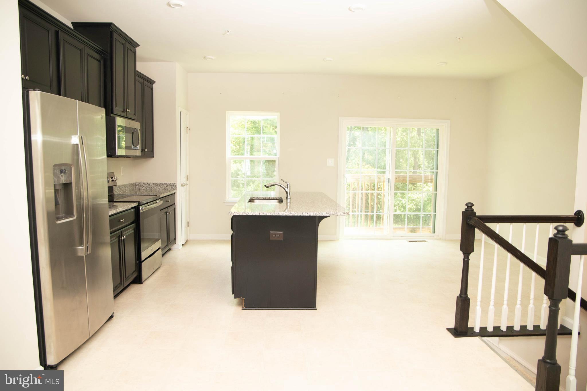 1813 Wind Gate Road Baltimore, MD 21227 - Photo 11 of 27 a kitchen with stainless steel appliances granite countertop a refrigerator a sink a stove and island
