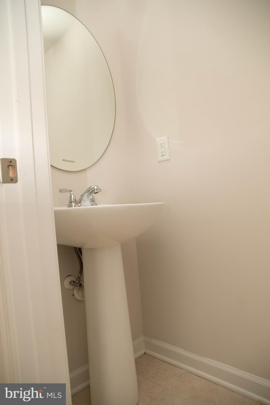 1813 Wind Gate Road Baltimore, MD 21227 - Photo 25 of 27 a bathroom with a sink and a mirror