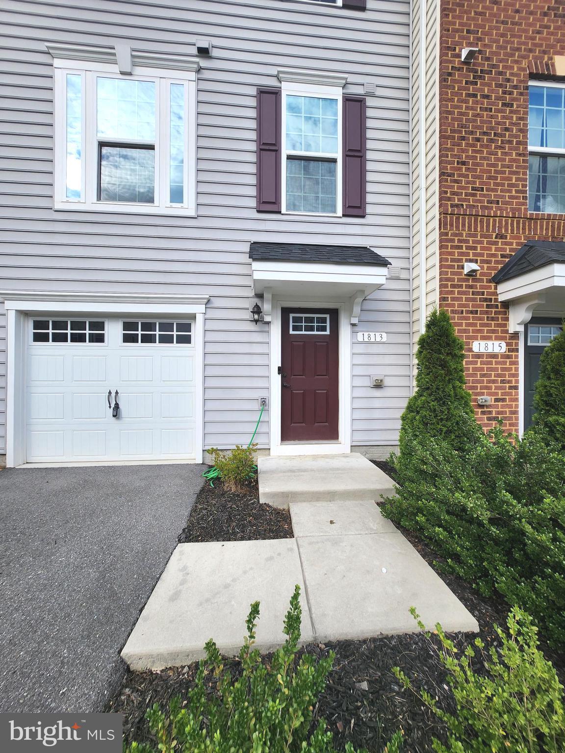 1813 Wind Gate Road Baltimore, MD 21227 - Photo 6 of 27 a front view of a house with a yard and garage