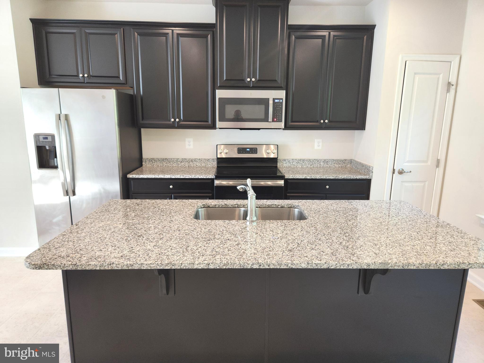 1813 Wind Gate Road Baltimore, MD 21227 - Photo 10 of 27 a kitchen with granite countertop a refrigerator a stove a sink and dishwasher