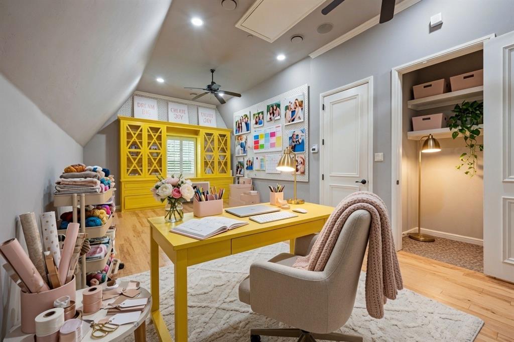 6900 Rockingham Court Colleyville, TX 76034 - Photo 23 of 40 Can be used as a Craft Room, Homeschool Room, or Private Office featuring hardwood flooring, a built-in yellow cabinetry unit with a desk and shelving, a window with plantation shutters, recessed lighting, and a ceiling fan