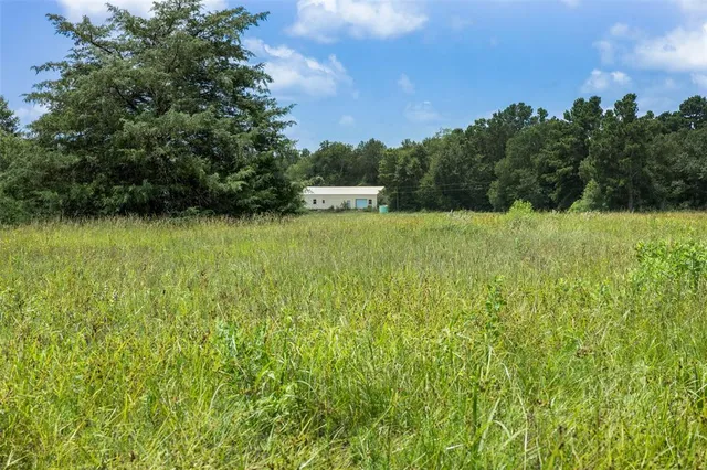a view of outdoor space with green field and trees