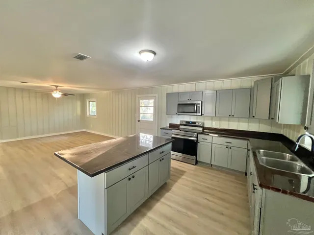 a kitchen with granite countertop a sink stove and cabinets