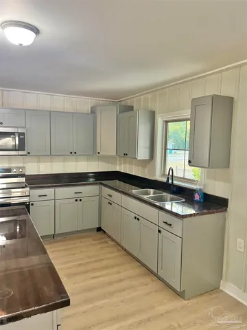 a kitchen with stainless steel appliances granite countertop a sink stove and cabinets
