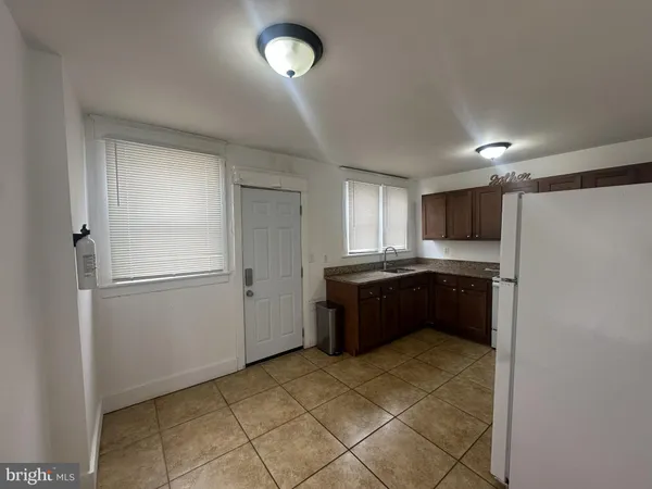 a large kitchen with a refrigerator and a stove top oven