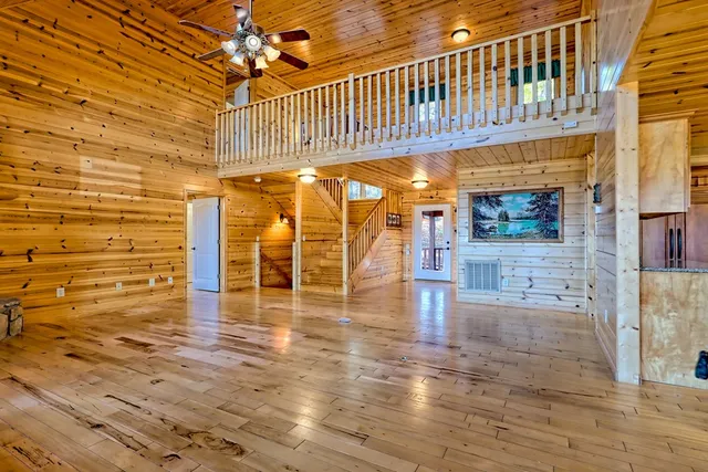 a view of empty room with wooden floor and fireplace