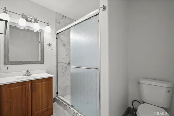a bathroom with a shower sink vanity and mirror