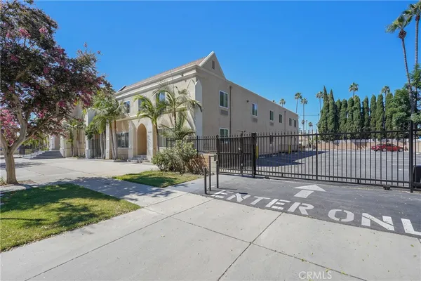 a view of a house with a small yard and potted plants